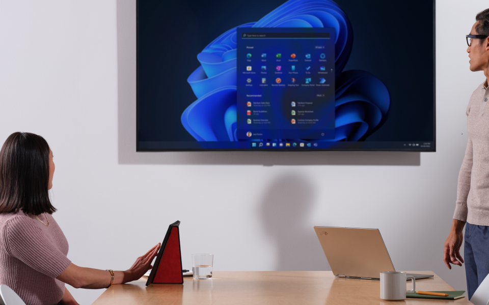 Zwei professionelle Anwender bei der Nutzung von Windows 11 Pro for Workstation auf einem großen Bildschirm für Präsentation und Zusammenarbeit.