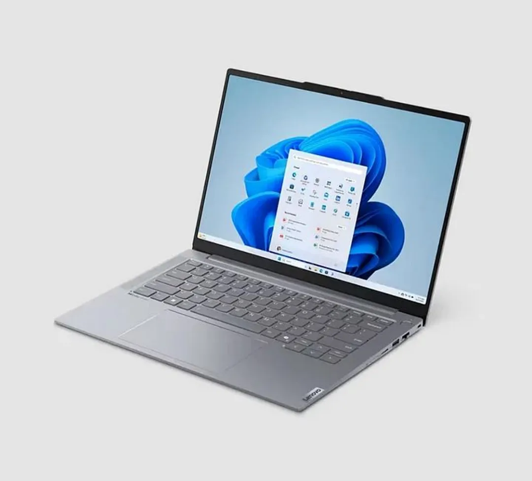 Un ordinateur portable élégant avec Windows 11 Home et Office 2024 Standard affichés sur un écran HD, posé sur une surface grise.
