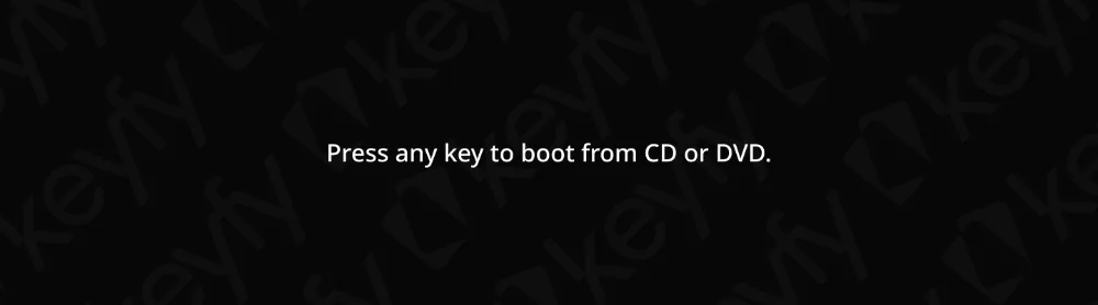 Le texte sur un écran noir indique : Appuyez sur n'importe quelle touche pour démarrer du CD-ROM ou DVD-ROM. L'arrière-plan a un motif de clé subtil et répétitif en gris.
