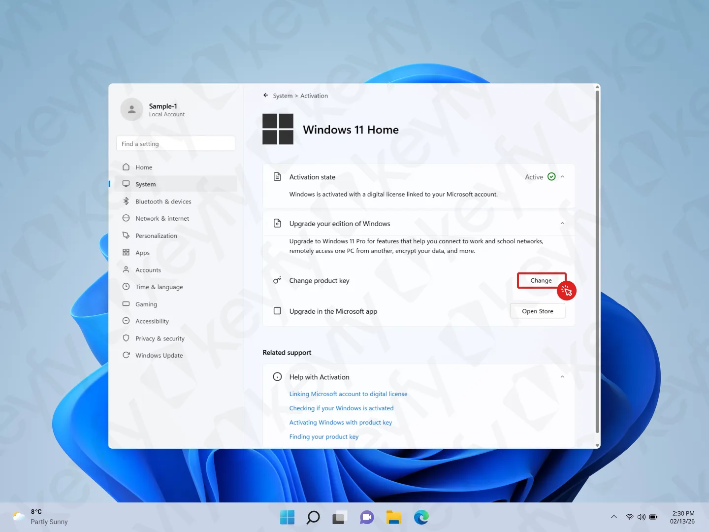 Une fenêtre de paramètres d'activation de Windows 11 Famille affiche les options de mise à niveau, dont un bouton « Modifier » mis en évidence sous « Modifier la clé de produit ». L'arrière-plan affiche un fond d'écran abstrait bleu et la barre des tâches en bas.