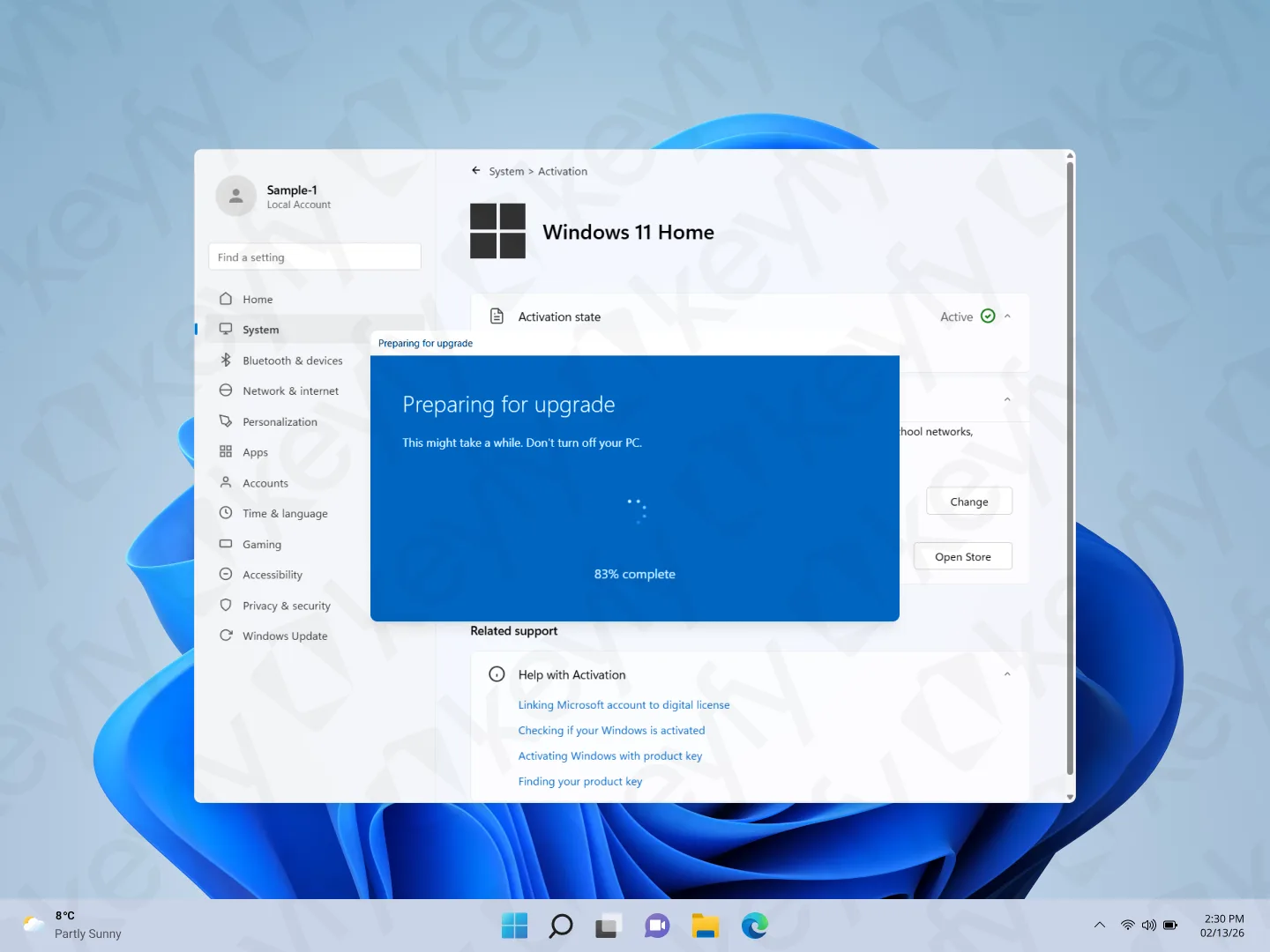 Un bureau Windows 11 Famille affiche une fenêtre de paramètres avec une fenêtre contextuelle bleue indiquant Préparation de la mise à niveau, 87 % terminés. L'arrière-plan montre le fond d'écran par défaut de Windows 11 et la barre des tâches en bas.