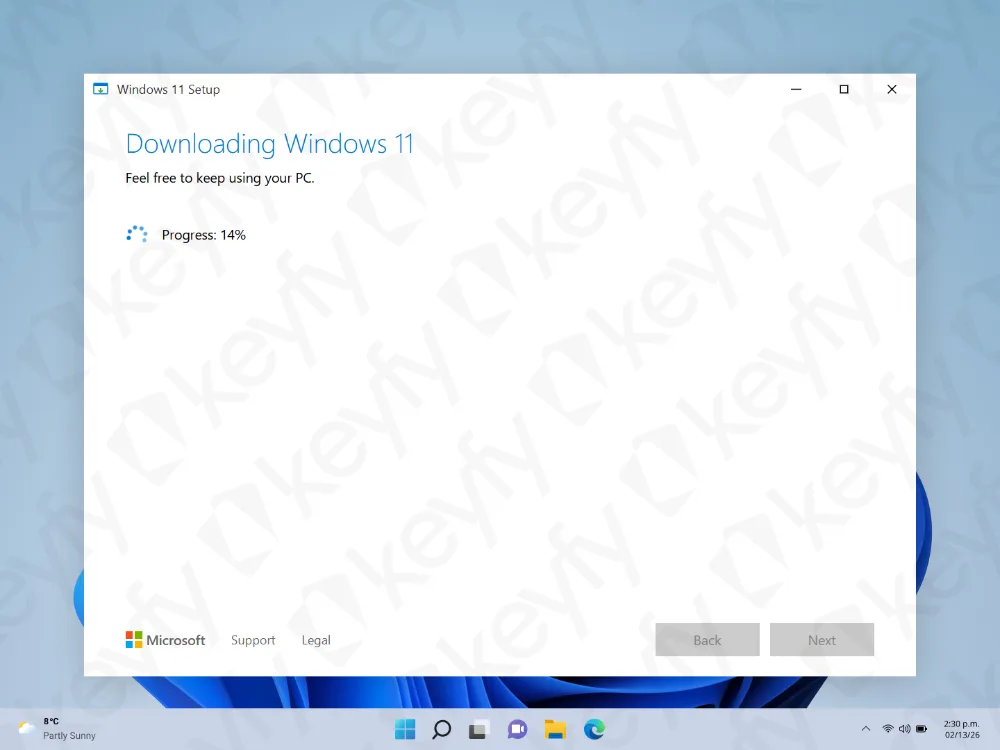 Une fenêtre de configuration de Windows 11 affiche « Téléchargement de Windows 11 » avec un indicateur de progression circulaire à 14 %. L'arrière-plan montre un bureau et une barre des tâches Windows partiellement visibles.