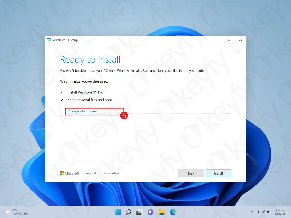 Écran de configuration de Windows 11 affichant Prêt pour l'installation avec les options pour installer Windows 11 Pro et conserver les fichiers personnels et les applications. Un curseur pointe vers Modifier ce qui doit être conservé. La barre des tâches et le fond d'écran bleu sont visibles.