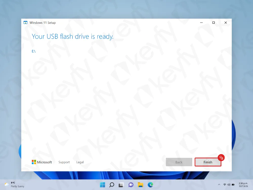 Un écran de configuration de Windows 11 affiche le message Votre disque mémoire flash USB est prêt. Le bouton Terminer est mis en évidence en rouge dans le coin inférieur droit. La barre des tâches du bureau est visible en bas.